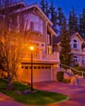 dusk on a neighborhood street with street lamps on