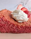 Whipped cream on top of strawberry cake.