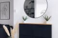 A black wall-mounted IKEA TRONES storage unit with two plants on the top