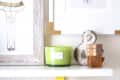 Shelf with framed art, green candle, metal ampersand, and wooden blocks.