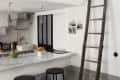Loft bed with red bedding above a kitchen with marble counter, black stools, and a wooden ladder.