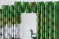 Green and white modular room divider with circular panels, next to a black office chair.