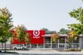 Target store exterior with red logo, surrounded by trees and a parked white truck.