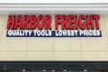Harbor Freight storefront with red and blue signage, glass doors, and sale posters.