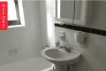 Small bathroom with pedestal sink, toilet, bathtub, and hexagonal tile floor.