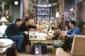 The main cast of Friends gathered around the living room of Monica's apartment in Christmas