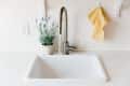 A white sink with a single handle is running