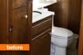 Small bathroom with wood paneling, white toilet, and vanity with a blue sink.