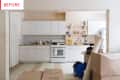 Cluttered kitchen with white cabinets, open shelves, blender, and boxes labeled "Before" in red text.