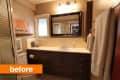 Bathroom with dark wood vanity, large mirror, towel rack, and framed sailboat painting.