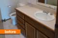 Small bathroom with wooden vanity, single sink, toilet, and shower.