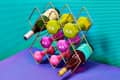 Wine rack holding colorful dumbbells and wine bottles on a purple surface with a teal background.