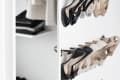 Closet with hanging clothes and wall-mounted shoe rack holding various high heels.