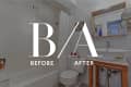 Bathroom renovation with white tiles, modern sink, wooden vanity, and decorative mirror.