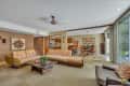 Mid-century modern living room with a large sectional sofa, coffee table, and open view to kitchen and dining area.