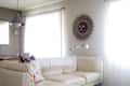 Cream sectional sofa in a bright living room with a sunburst wall decor and shag rug.