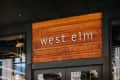 West Elm store entrance with wooden sign and glass doors.