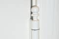 Close-up of a white painted door hinge with visible wear and chipping.