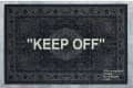 Dark patterned rug with large white text "KEEP OFF" in the center.