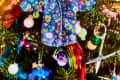 Christmas tree with colorful ornaments, including a floral shirt, disco balls, rainbow, and scissors.