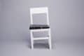White chair with a black marble seat on a gray background.