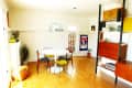 Mid-century modern dining room with round table, mixed chairs, pendant light, and wall art.