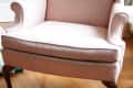 Pink wingback chair with wooden legs on a hardwood floor, labeled "Before."