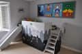 Kids' room with superhero-themed loft bed, slide, stairs, and wall art featuring Batman, Superman, Captain America, and Robin.