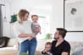 Family in living room with a concrete coffee table, gold skull decor, and framed portrait on the wall.