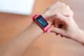 Person checking a pink fitness tracker displaying a heart rate of 131 bpm.