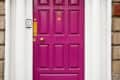 Bright pink door with number 31, flanked by white columns and an arched transom window.