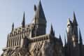 Gothic-style castle with tall spires and turrets on a rocky cliff.