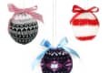 Three knitted Christmas ornaments with red, blue, and pink bows, featuring Nordic patterns in black, red, and white.
