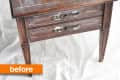 Worn wooden side table with two drawers and decorative handles, labeled "before."