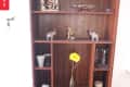 Wooden shelf with figurines, glassware, a yellow flower in a vase, and a candle, labeled "Before" on the left.