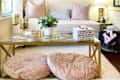 Cozy living room with floral wall decals, plush pillows, glass coffee table, and decorative candles.