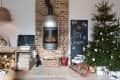 Cozy living room with a brick fireplace, Christmas tree, sled, and festive decor.