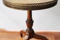 Round wooden side table with ornate metal trim and tripod base, labeled "before."