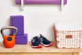 Home gym setup with yoga mats, kettlebell, sneakers, and motivational sign on a shelf.