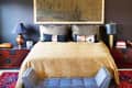 Cozy bedroom with a beige bedspread, decorative pillows, dark wood side tables, and modern lamps.