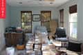 Cluttered room with stacked boxes, office chair, desk, and ceiling fan, labeled "Before."