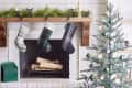 Fireplace with three stockings, green mailbox, and decorated Christmas tree with green and white ornaments.
