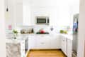 A white kitchen with marble countertops