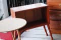 Wooden side table and dresser on a snowy porch with a small round table.