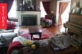 Living room with a vintage piano, red curtains, white sofa, and a red patterned rug.