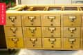 Wooden card catalog with brass handles and label slots, marked "Before."