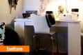 Home office with white desk, chair, table lamp, wall art, and jewelry organizer.
