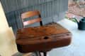 Worn wooden school desk with attached chair on a porch, labeled "Before."