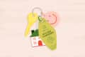 Keychain with a yellow key, house charm, smiley face, and tag reading "The Key to an Accessible Thanksgiving" with a turkey.