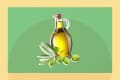 Glass bottle of olive oil with green olives and leaves on a green background.